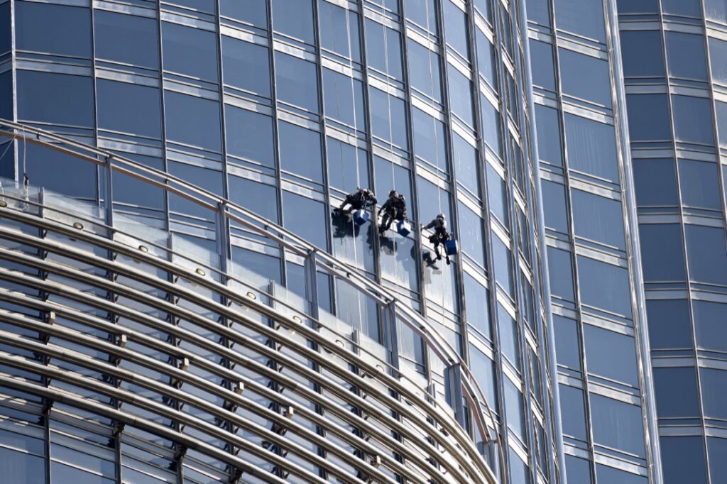 Rope-access window cleaners on a high-rise glass tower